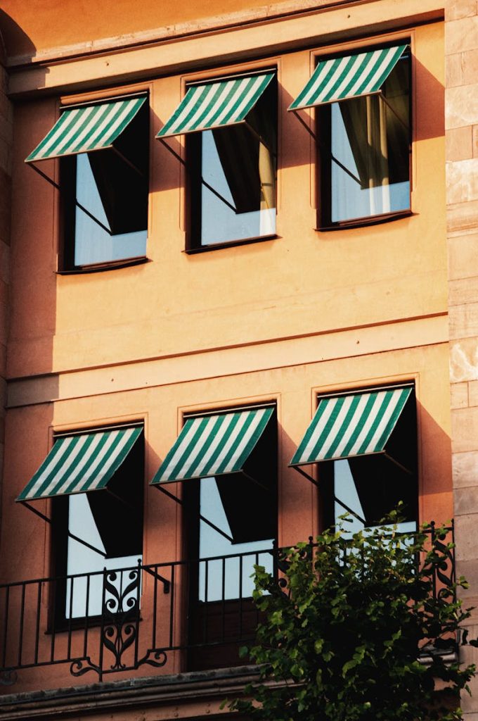 Stockholm building facade with striped awnings and warm sunlight accents urban architecture.