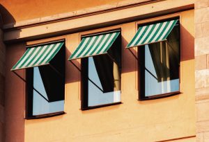 Stockholm building facade with striped awnings and warm sunlight accents urban architecture.